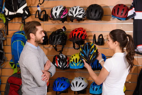 Молода Жінка Менеджер Показує Велосипедний Шолом Усміхненому Клієнту Велосипедному Магазині — стокове фото