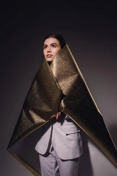 Портрет Модной Задумчивой Женщины Золотой Оберточной Бумаге Смотрящей Сторону Темном — Бесплатное стоковое фото