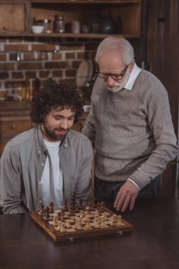 Yetişkin oğlu ve üst düzey satranç birlikte evde baba