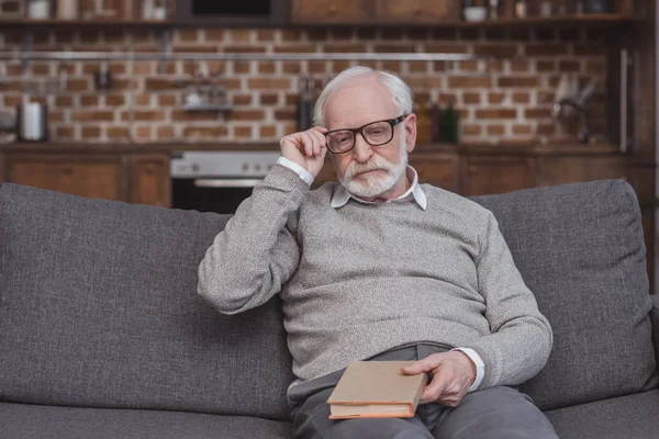 Guapo Gris Pelo Hombre Tocando Gafas Sosteniendo Libro Casa — Foto de stock gratis