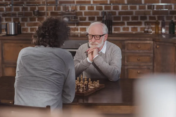 Ενήλικα Γιο Και Ανώτερος Πατέρας Σκέψης Παίζοντας Σκάκι Στο Σπίτι — Δωρεάν Φωτογραφία