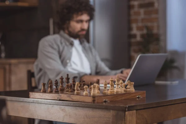 Schöner Mann Mit Laptop Und Schachbrett Vordergrund — kostenloses Stockfoto