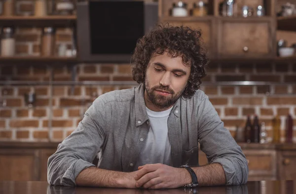 Nachdenklicher Gutaussehender Mann Sitzt Hause Holztisch — Stockfoto