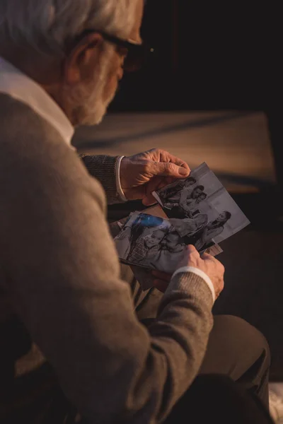 Senior man kijken naar oude foto 's — Stockfoto