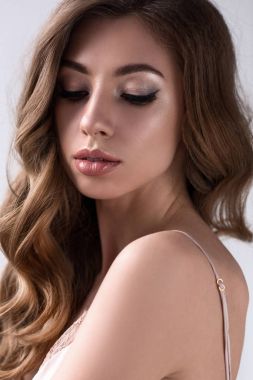 makyaj ve uzun kıvırcık saçlı, gri izole ile şehvetli kız portresi