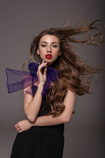 attractive elegant girl with long hair posing for fashion shoot, isolated on grey