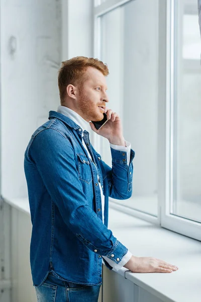 Νεαρός Άνδρας Μιλάει Στο Τηλέφωνο Από Παράθυρο — Φωτογραφία Αρχείου