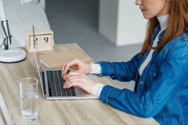 Laptop çalışma masasında yazarak kadın