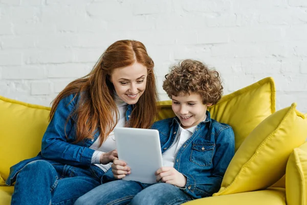 Son Tenant Tablette Tout Étant Assis Sur Canapé Avec Mère — Photo