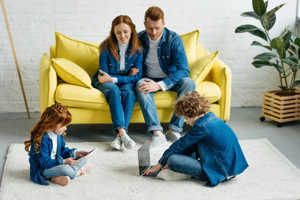 Padres Felices Sentados Sofá Mirando Los Niños Usando Computadora Portátil — Foto de Stock