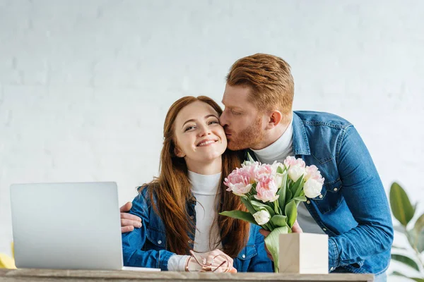 Man Giving Bouquet Tulips Young Woman Working Laptop — Stock Photo, Image