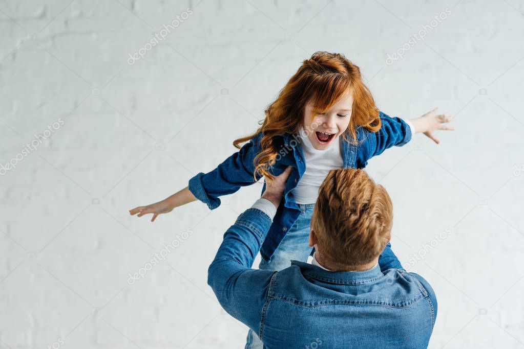 Redhead father and daughter playing together