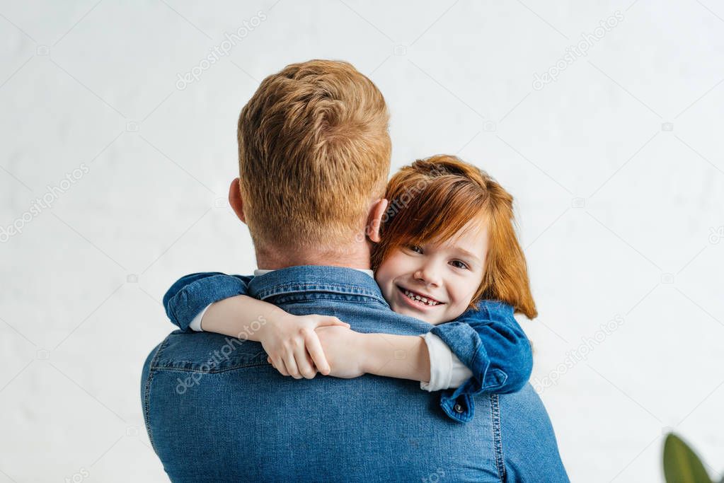 Cute little daughter hugging her father