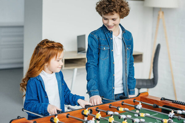 Cute children playing table football together