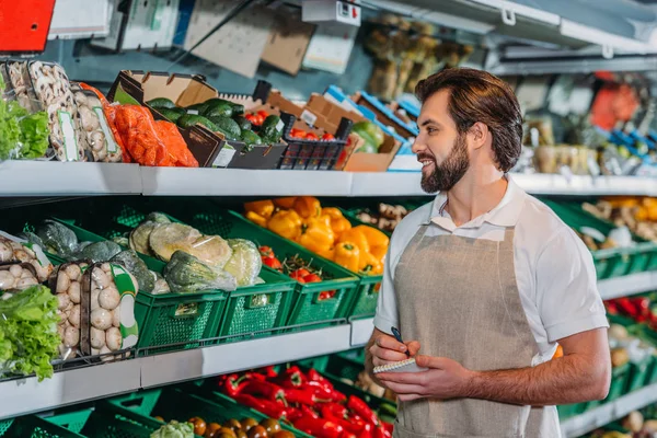 Portrait Smiling Shop Assistant Apron Notebook Supermarket — Stock Photo, Image