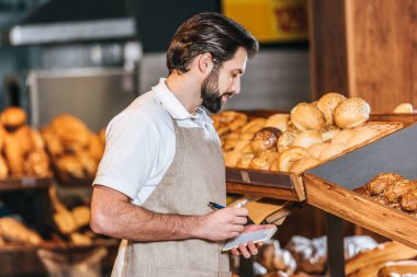erkek tezgâhtar süpermarkette Not defterinizdeki notlar yapma önlük