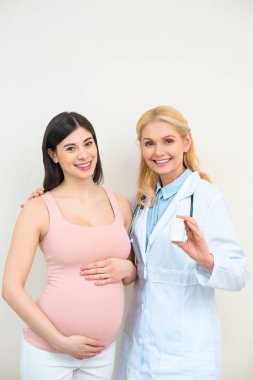 doğum uzmanı jinekolog ve kavanoz kameraya bakarak hap ile hamile kadın