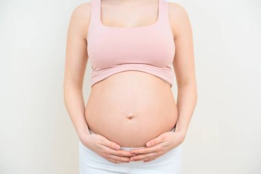 cropped shot of pregnant woman holding her belly on white clipart