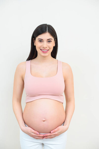 smiling young pregnant woman on white