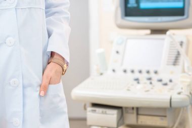 arka plan üzerinde ultrasonik tarayıcı ile doğum uzmanı jinekolog paltolu kadeh kırpılmış