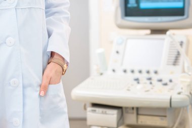 cropped shot of obstetrician gynecologist in coat with ultrasonic scanner on background clipart
