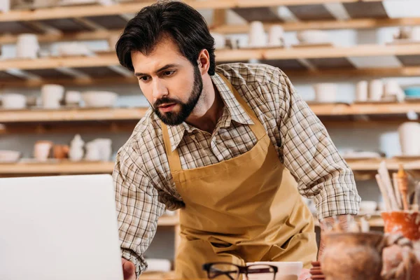 Ceramista Maschio Grembiule Che Lavora Con Laptop Officina — Foto Stock