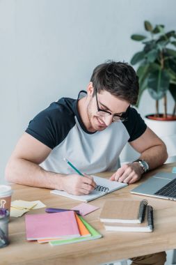 yazı defterini içinde gözlük yakışıklı gülümseyen öğrenci