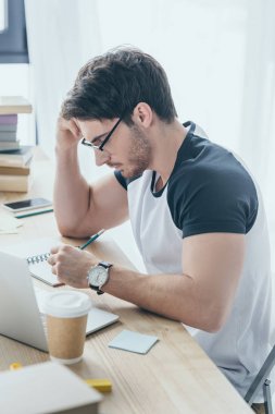 defterini ve dizüstü bilgisayar ile yakışıklı öğrenci