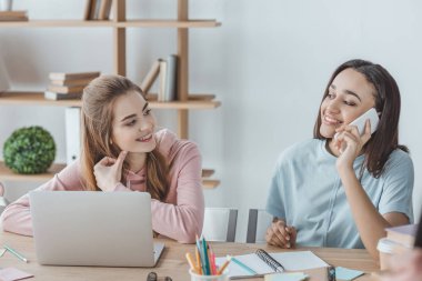 Smartphone ve dizüstü bilgisayar kullanan çekici çok ırklı öğrenciler