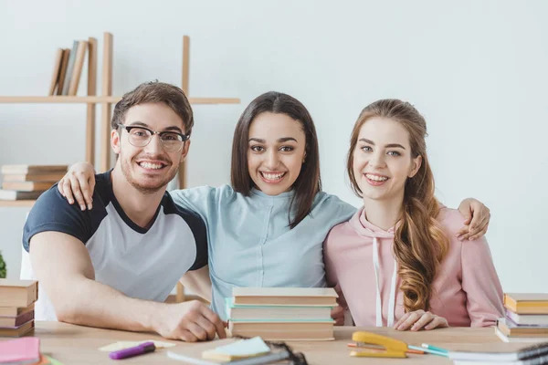 Jóvenes Estudiantes Sonrientes Sentados Mesa Con Libros — Foto de Stock