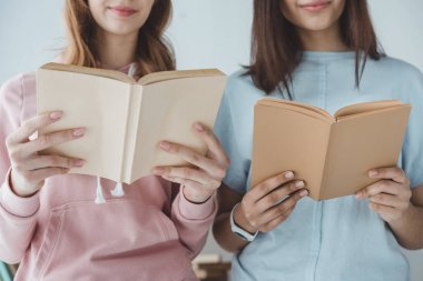 kırpılan kız öğrencilerin birlikte kitap okuma görünümünü