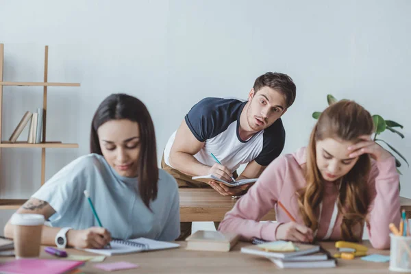 Jovens Estudantes Escrevendo Exame Enquanto Homem Escrevendo — Fotografia de Stock