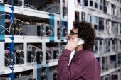 junger Computeringenieur telefoniert auf der Minenfarm von Ethereum