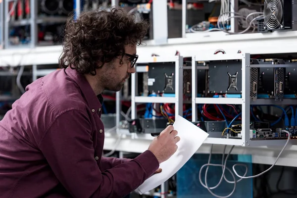 Young Computer Engineer Writing Paper Cryptocurrency Mining Farm — Stock Photo, Image