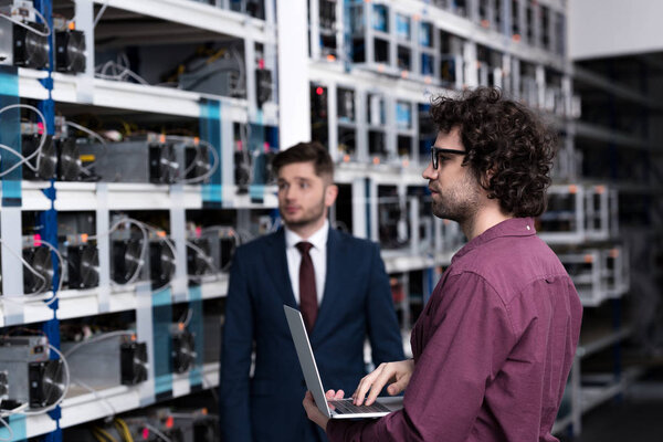 successful businessman and computer engineer working together at bitcoin mining farm