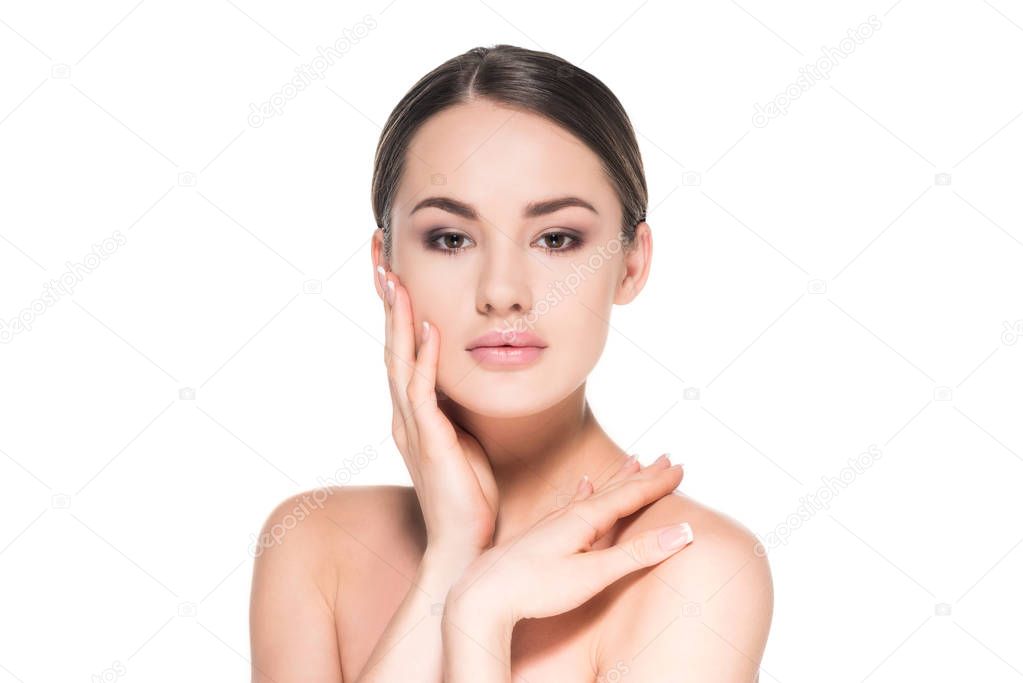 beautiful young woman with clear skin touching her face isolated on white