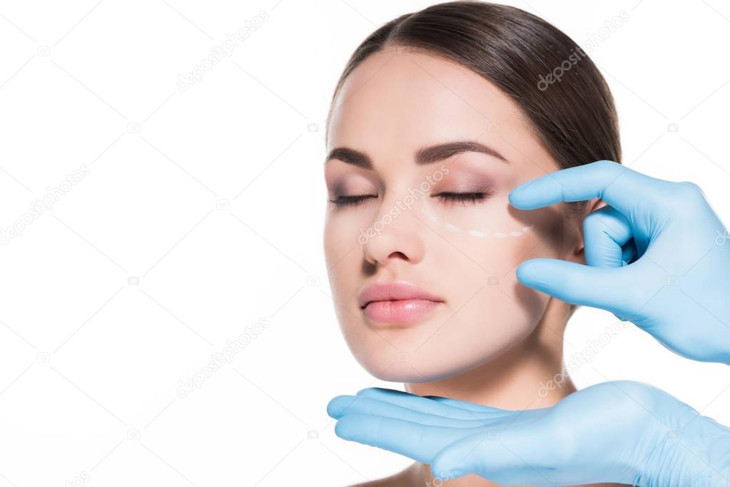 doctor touching face of young woman with dotted line for plastic surgery isolated on white