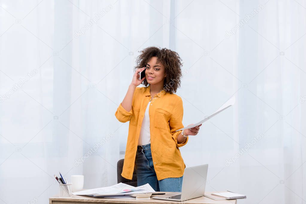 beautiful woman with business papers talking by phone
