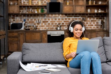 laptop ile çalışma ve evde müzik dinleme çekici genç kadın