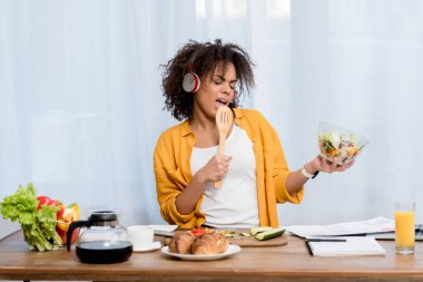 müzik dinleme ve mutfak at salata hazırlama ifade genç kadın