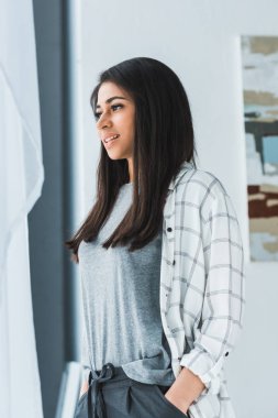 Çekici gülümseyen kız ayakta ve vitrinlere bakıyor