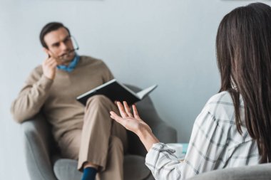 Kadın erkek doktor ofisinde karşısında onun sağlığı hakkında şikayet