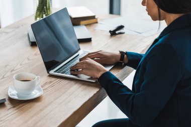 Afro-Amerikan işkadını üstünde laptop ofiste tabloda yazmaya
