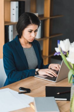 Ofis Masası tarafından dizüstü bilgisayar ekranına bakarak çekici iş kadını