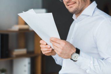 Office gazetelerde okuyan işadamı gülümseyen