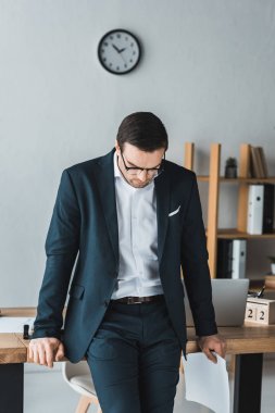 Düşünceli işadamı takım elbise ve ofiste tabloda hazır gözlük