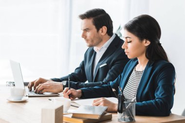 İş arkadaşları tarafından tablo modern ofis içinde laptop ile çalışma