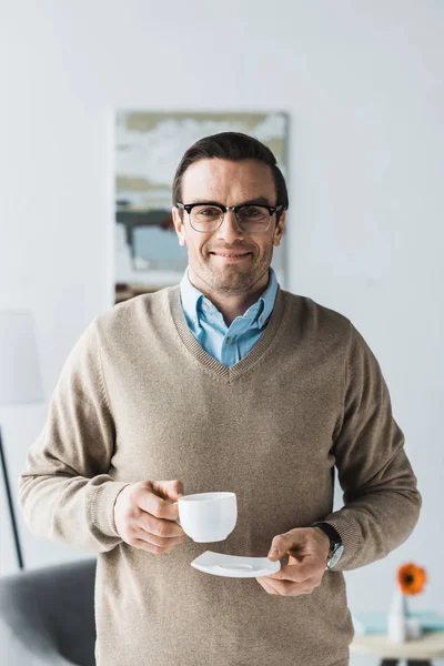 Ευτυχισμένος Άνθρωπος Φορώντας Γυαλιά Και Κρατώντας Φλιτζάνι Του Καφέ — Δωρεάν Φωτογραφία