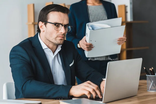 Geschäftsmann Arbeitet Laptop Von Geschäftsfrau Mit Ordnern — Stockfoto