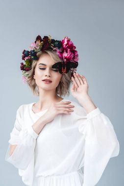 çekici kız kelebek, gri izole ile çiçek çelenk poz